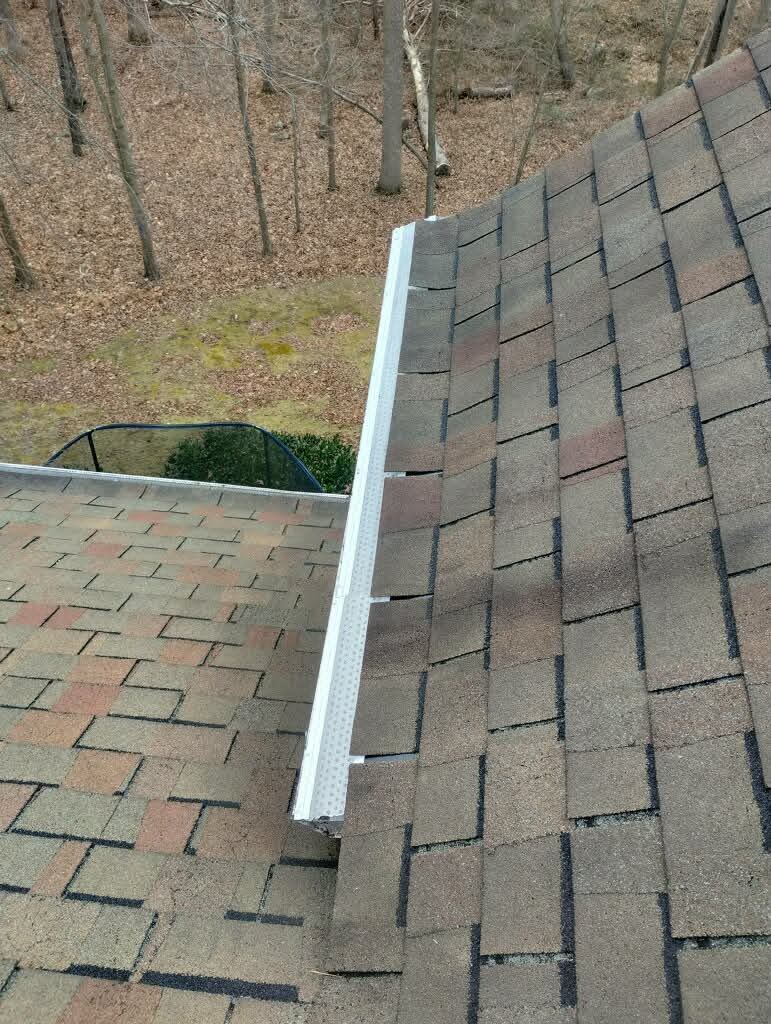 A guard fitted along the gutter where two rooflines meet, keeping the run clear