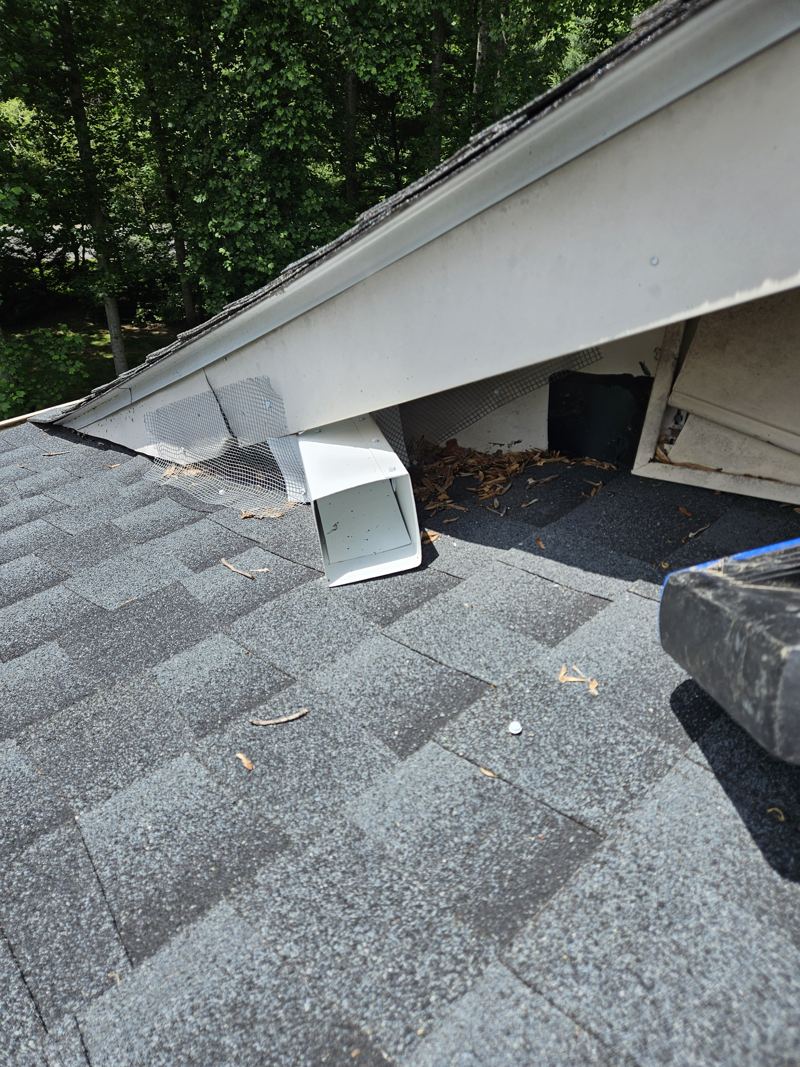 A one-way door installed on a roofline with mesh sealing the surrounding gap