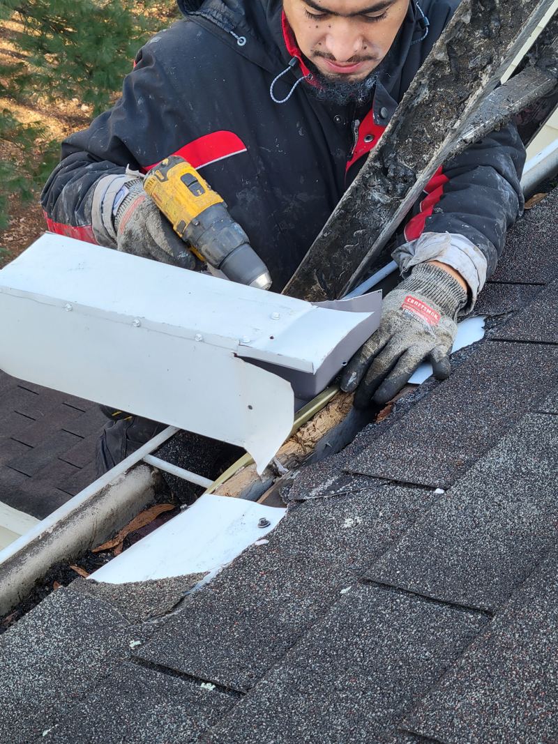 Fitting a metal repair piece over a damaged soffit from a ladder